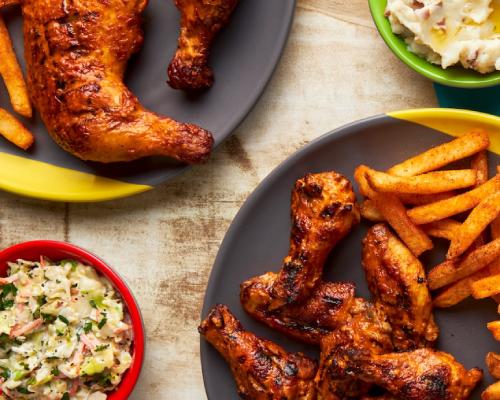 chicken wings and fries on plates from Nandos